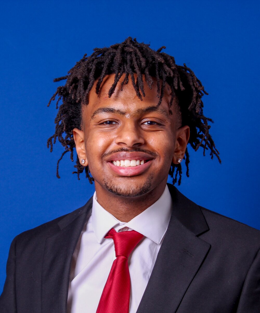 Kaleb Alemayehu, 2026 East African Youth Scholarship recipient, in a black suit and red tie